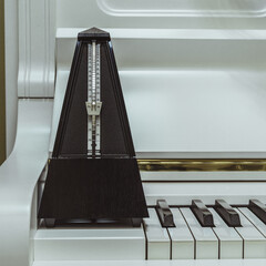 metronome and white piano