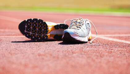 Taking a break from the race. A pair of running shoes lying on a running track.