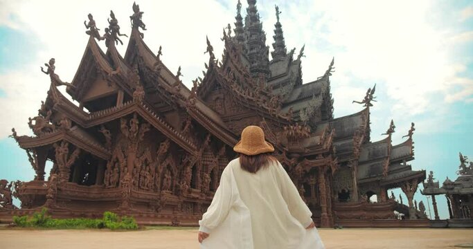 Sanctuary of Truth (Prasat Sut Ja-Tum), Rear view of woman 
tourist at beautiful Thai wooden temple interior in Pattaya Thailand, Amazing Thailand travel concept.