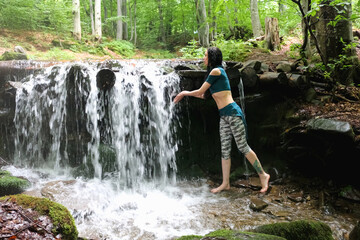 woman near mountain waterfall