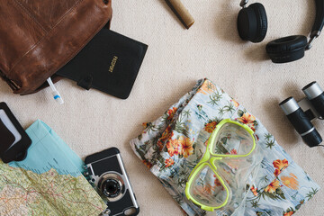 Flat lay style overhead shot of vacation or travel items. Things to pack for a trip or holiday. Cool vintage style with copy space available