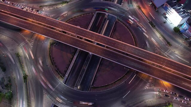 aerial view, Hyperlapse time-lapse of car traffic transportation above circle roundabout road in Asian city. Drone aerial view fly in circle, high angle. Public transport or commuter city life concept