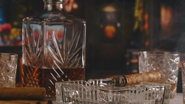 Cuban cigar and a glass of cognac brandy in bar, closeup view