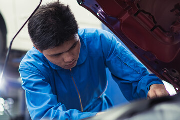 Asian automobile mechanic man checking car damage broken part  condition, diagnostic and repairing vehicle at garage automotive, motor technician maintenance after service concept
