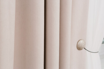 beige curtain folds and white tulle close up photo on window background