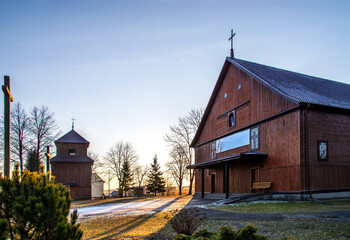 General view and close-up of architectural details of the sacred complex built in 1921, i.e. the belfry and the Catholic Church of the Rosary Mother of God in the village of Kuzie in Podlasie, Poland.