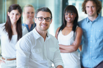 The team that wins. Cropped shot of a businessman sitting in front of his colleagues in the office.