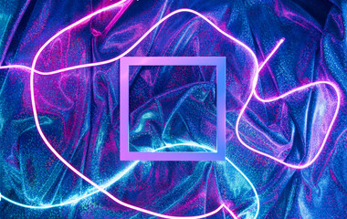 Neon led lights with square frame on a colorful fabric background. Futuristic abstract backdrop.