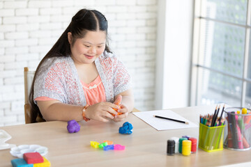down syndrome girl sculpt plasticine figures on a table