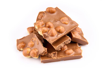 Macro photo of Chocolate bar. Broken pieces over white background. Pieces of milk chocolate with nuts isolated on white background