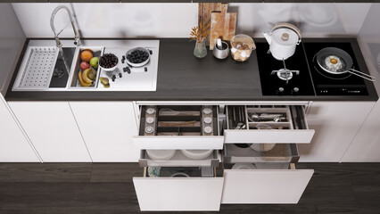 Dark wooden kitchen close up, open drawers with accessories, sink with fruit, hob with pot, fried egg in a pan, cutting boards. Top view, above with copy space, interior design