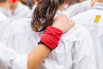 Non-recognizable people with their hand on the back of another preparing to make Castellers or...