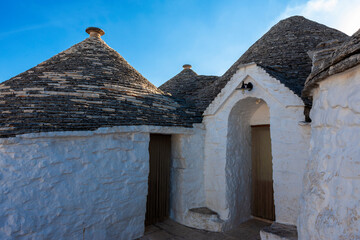 Fototapeta na wymiar Trullo (traditional dry stone hut with the roof made of dry-set slabs) on Via Giuseppe Verdi, Aia Piccola, Alberobello, Puglia, Southern Italy