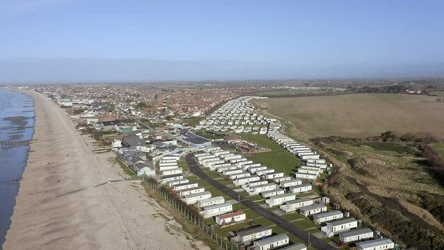 Aerial footage along the south coast by Bracklesham Bay and the holiday resort caravan park near East Wittering.