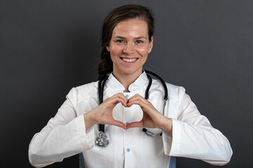 girl doctor in uniform taking care of the heart shows with her hands