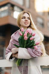 Beautiful girl with a bouquet of pink tulips
