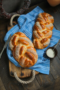 Sweet braided buns with sesame seeds on a blue kitchen towel. Sweet yeast pastry