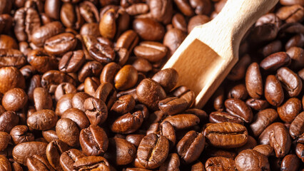 Freshly roasted coffee beans background.Dark roasted coffee beans with scoop on wooden background.