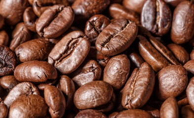 Freshly roasted coffee beans background.Dark roasted coffee beans with scoop on wooden background.