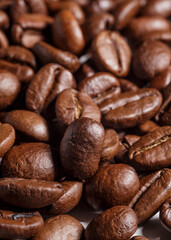 Freshly roasted coffee beans background.Dark roasted coffee beans with scoop on wooden background.