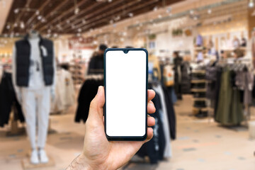 Blank smartphone screen on fashion shopping mall blurred background. Digital retail, e-commerce, shopping, app concept