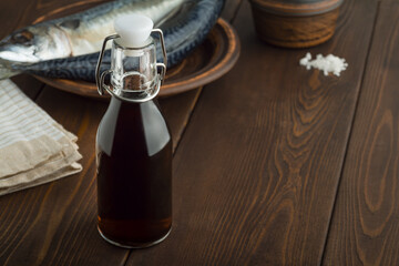 prepared by fermentaion of fish salty sauce garum in a bottle on brown wooden background
