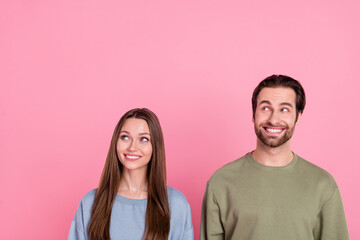 Photo of two attractive positive people toothy smile look interested empty space isolated on pink color background