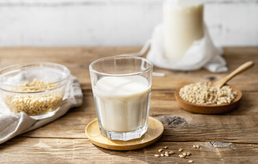 Barley milk in glass on the wooden table with ingredients