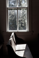 Black and White church pew by a window 