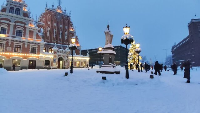 Snow-covered buildings and lanterns on a street in Riga, Latvia. 