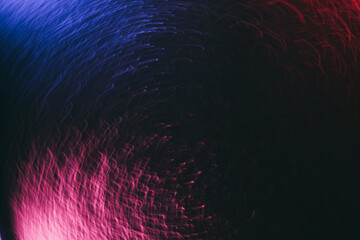 Blur glow overlay. Neon swirl. Festive radiance. Defocused fluorescent blue pink red color light strokes on dark black abstract background.