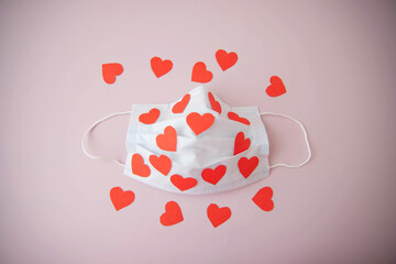 Medical mask in red hearts on a pink background