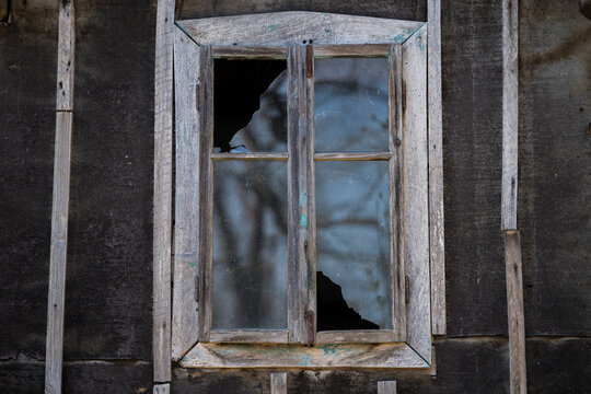 Sunja, Croatia, 05,04,2021: Rustic style aged window in wooden village rural home wall.