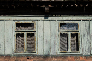 Sunja, Croatia, 05,04,2021: Rustic style aged window in wooden village rural home wall.