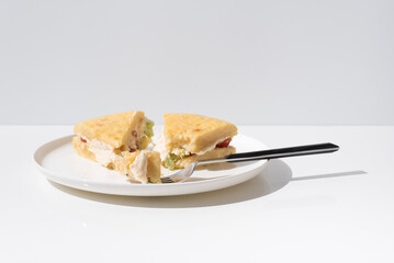Tortilla de patata rellena de tomate, lechuga y mayonesa, hecha con aceite de oliva, huevos y...
