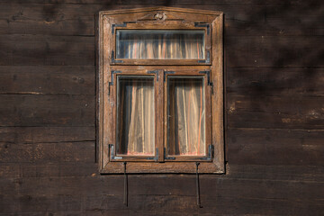 Sunja, Croatia, 05,04,2021: Rustic style aged window in wooden village rural home wall.