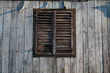 Sunja, Croatia, 05,04,2021: Rustic style aged window in wooden village rural home wall.
