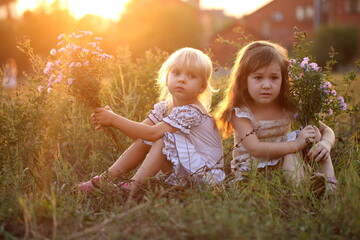 Two little girls with a bouquet of flowers in the park