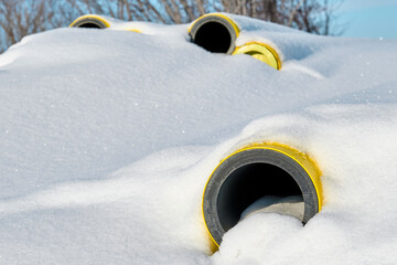 Yellow gas pipes under the snow.