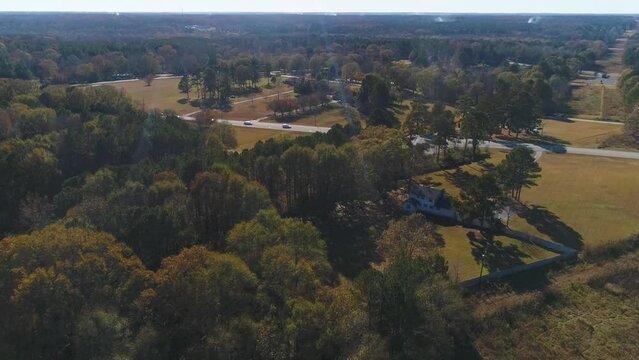 Aerial drone fly over a busy road in the countryside with trees