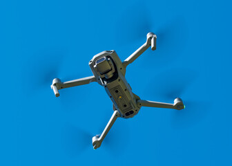 Drone. Professional drone with 4K or 5K camera for take a video, photo, film, movie footage. Aerial photography or videography. Flying on blue sky background. Flight technology. 