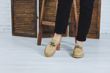 Close-up of female legs in black jeans in stylish leather beige shoes. Fashionable woman in new...