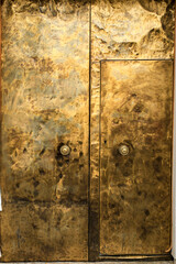 Golden metal door with wrought iron details