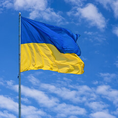 Ukraine flag isolated on the blue sky. Close up waving flag of Ukraine. Flag symbols of Ukraine.