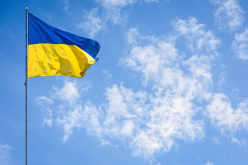 Ukraine flag isolated on the blue sky. Close up waving flag of Ukraine. Flag symbols of Ukraine.