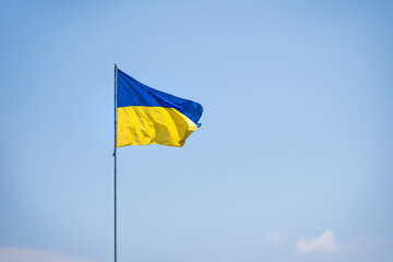 Ukraine flag isolated on the blue sky. Close up waving flag of Ukraine. Flag symbols of Ukraine.