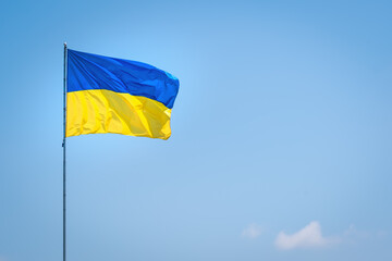 Ukraine flag isolated on the blue sky. Close up waving flag of Ukraine. Flag symbols of Ukraine.