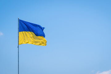 Ukraine flag isolated on the blue sky. Close up waving flag of Ukraine. Flag symbols of Ukraine.