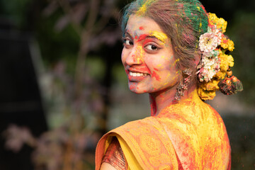 Festival of color holi, Young beautiful girl or woman or lady in indian attire saree looking back...