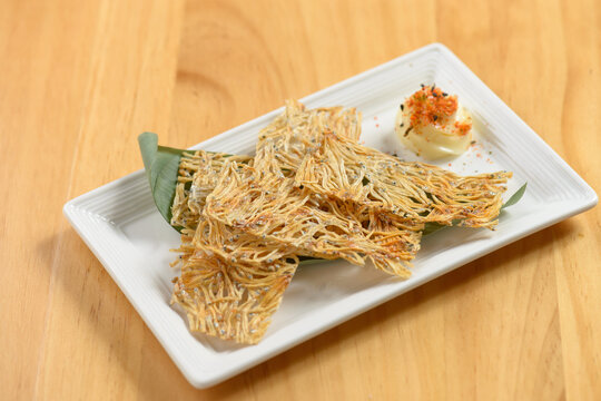 japanese food fried Tatami Iwashi in a white dish isolated on wooden table top view